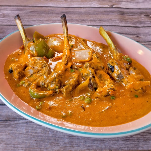 Indian lamb chops in a rich orange sauce with green peppers, onions, and peas.