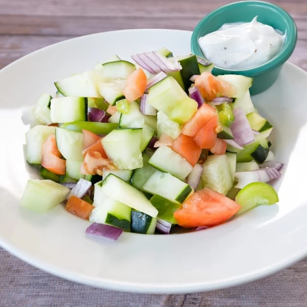 A Bengal Tiger Cuisine Of India kachumber salad with diced cucumbers, tomatoes, and red onions, served with raita.